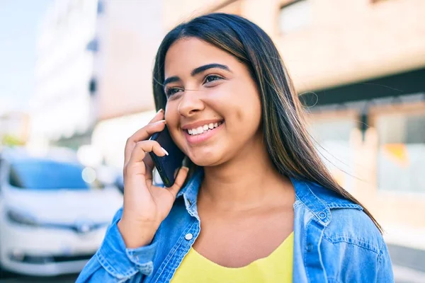 若いラテン語の女性笑顔幸せな話上のスマートフォンで街 — ストック写真