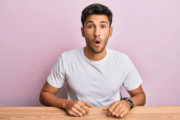 Jovem Homem Bonito Vestindo Casual Shirt Branca Sentado Mesa Assustado — Fotografia de Stock