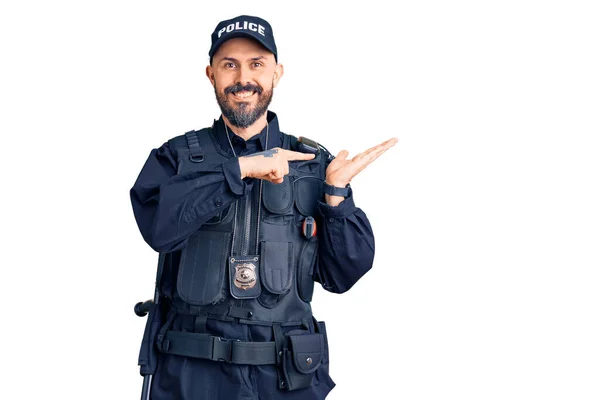 手で提示しながら警察の制服を着た若いハンサムな男は驚きとカメラに笑顔と指で指して — ストック写真