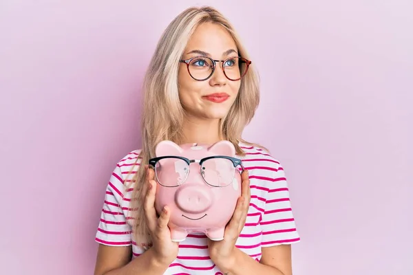 Mooi Blank Blond Meisje Holding Piggy Bank Met Bril Glimlachen — Stockfoto