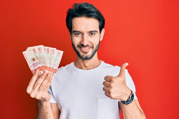 Young Hispanic Man Holding Colombian Pesos Banknotes Smiling Happy Positive — Stockfoto