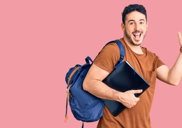 Ung Latinamerikan Man Bär Student Ryggsäck Innehav Pärm Firar Seger — Stockfoto