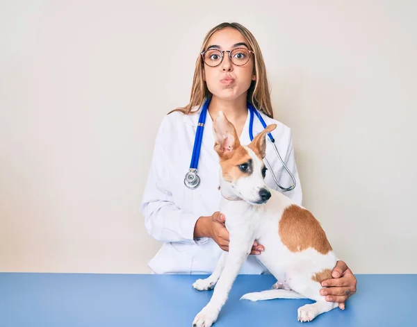 若い美しいブロンドの獣医師の女性は犬の健康をチェック面白い顔で頬をパフ 空気を吸い込み空気を吸い込み — ストック写真