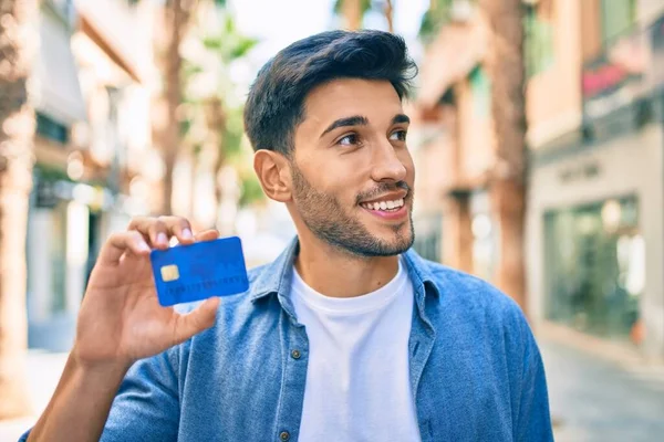 Joven Latino Sonriendo Feliz Sosteniendo Tarjeta Crédito Caminando Por Ciudad —  Fotos de Stock