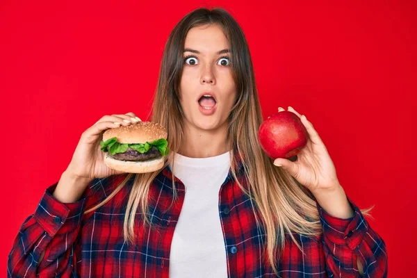 Όμορφη Καυκάσια Γυναίκα Σύγκριση Burger Και Υγιή Κόκκινο Μήλο Φοβάται — Φωτογραφία Αρχείου