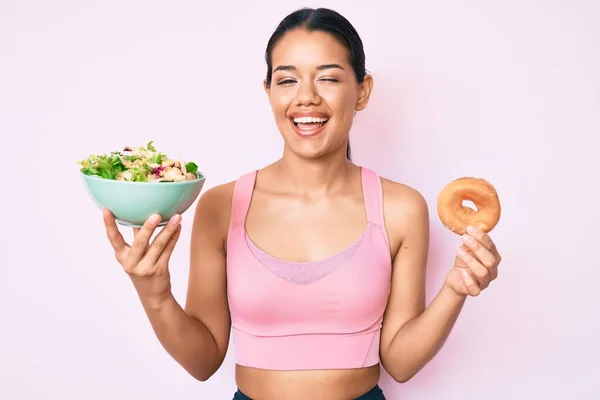 Joven Hermosa Chica Latina Con Ropa Deportiva Sosteniendo Donut Ensalada —  Fotos de Stock