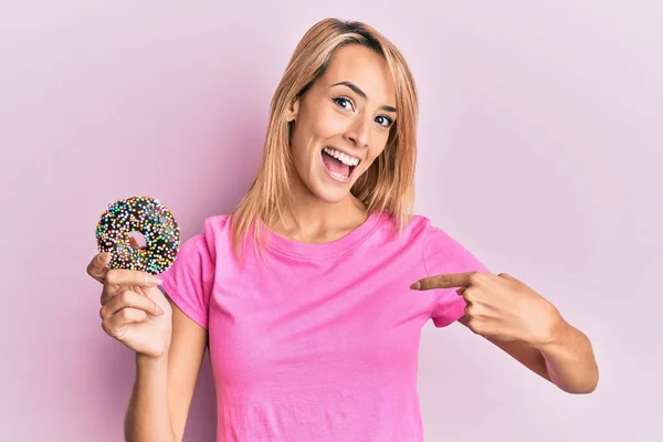 Hermosa Mujer Rubia Sosteniendo Donut Señalando Dedo Uno Mismo Sonriendo —  Fotos de Stock