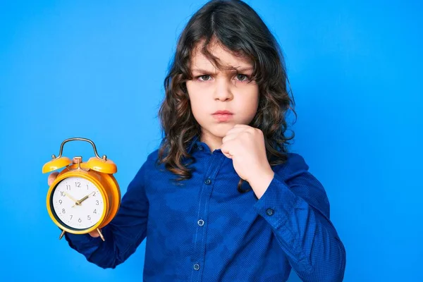Cute Hispanic Child Long Hair Holding Alarm Clock Annoyed Frustrated — Stock Photo, Image