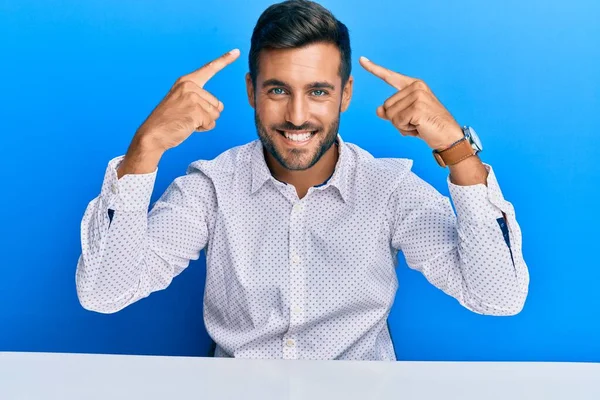 Hombre Hispano Guapo Usando Ropa Negocios Sentado Mesa Sonriendo Apuntando —  Fotos de Stock