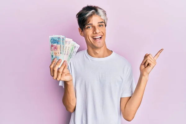 Fiatal Spanyol Férfi Kezében Singapore Dollár Bankjegyek Mosolyogva Boldog Mutató — Stock Fotó