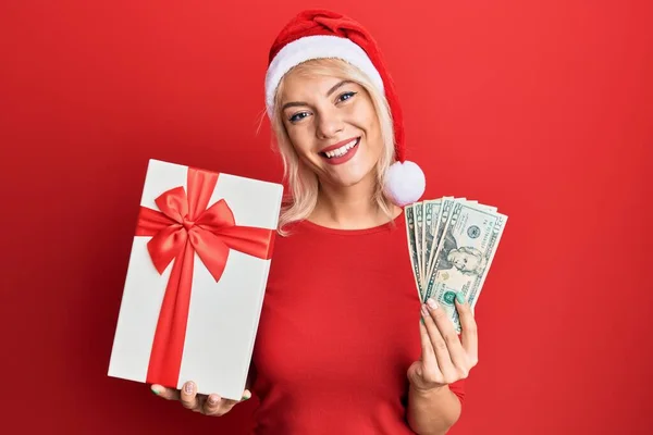 Молода Блондинка Різдвяному Капелюсі Тримає Подарунок Долари Посміхається Щасливою Прохолодною — стокове фото