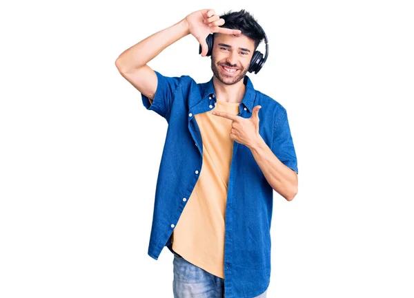 Young Hispanic Man Listening Music Using Headphones Smiling Making Frame — Stock Photo, Image