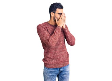 Kışlık süveter giyen ve ağlarken suratını ellerle kapatan üzgün yüzlü gözlüklü yakışıklı İspanyol bir adam. depresyon kavramı. 