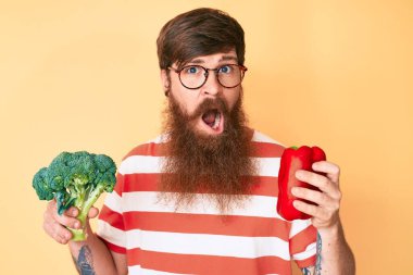 Uzun sakallı, yüzünde kırmızı biber ve brokoli olan yakışıklı genç bir adam. Şüpheci ve alaycı görünüyor. 