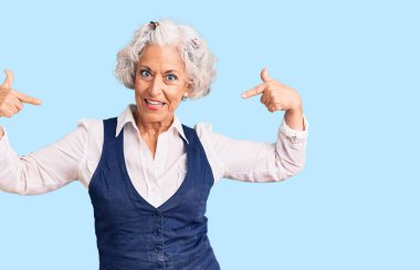 Üstün gri saçlı, günlük kıyafetler giyen, kendine güvenen, gülümseyen, kendini gururlu ve mutlu gösteren bir kadın.. 