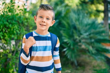 Kafkasyalı bir öğrenci parkta mutlu bir şekilde gülümsüyor..