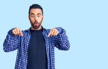 Gündelik giysiler giymiş genç İspanyol bir adam parmaklarını göstererek reklamını yapıyor, şaşırmış bir yüz ve ağzını açıyor. 