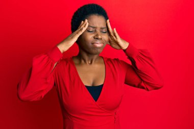 Afro saçlı, kırmızı arka planda günlük kıyafetler giyen, başı ağrıyan, başı ağrıyan genç bir Afrikalı kadın. migren ağrısı. 