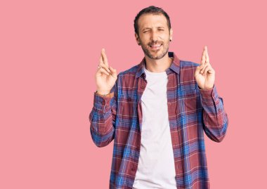 Sıradan kıyafetler giyen genç yakışıklı adam umut ve gözlerin kapalı gülümseyerek el sallıyor. Şans ve batıl inançlar. 