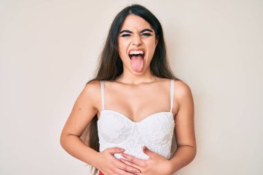 Esmer kız zarif bir dille komik bir ifadeyle poz veriyor. duygu kavramı. 