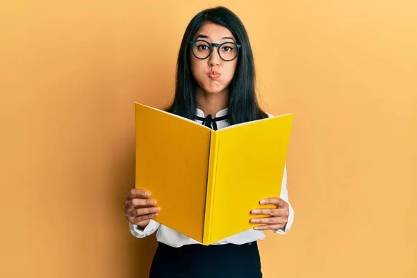 Hermosa Mujer Joven Asiática Leyendo Libro Con Gafas Hinchando Mejillas — Foto de Stock