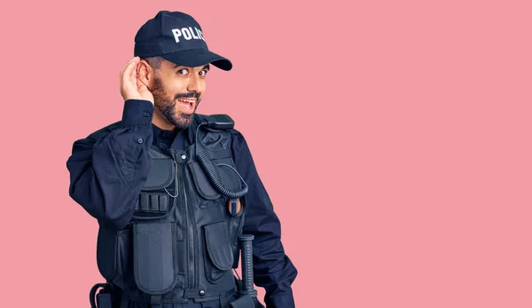 Joven Hispano Con Uniforme Policial Sonriendo Con Mano Sobre Oreja —  Fotos de Stock