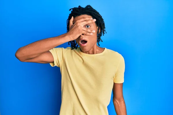 Jovem Afro Americano Vestindo Roupas Casuais Espreitando Choque Cobrindo Rosto — Fotografia de Stock