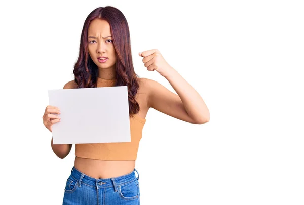 Young Beautiful Chinese Girl Holding Paper Banner Blank Space Annoyed — Stock Photo, Image