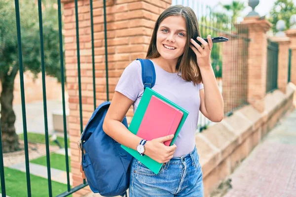 Νεαρή Μαθήτρια Της Μέσης Ανατολής Που Κρατάει Βιβλία Χρησιμοποιώντας Smartphone — Φωτογραφία Αρχείου