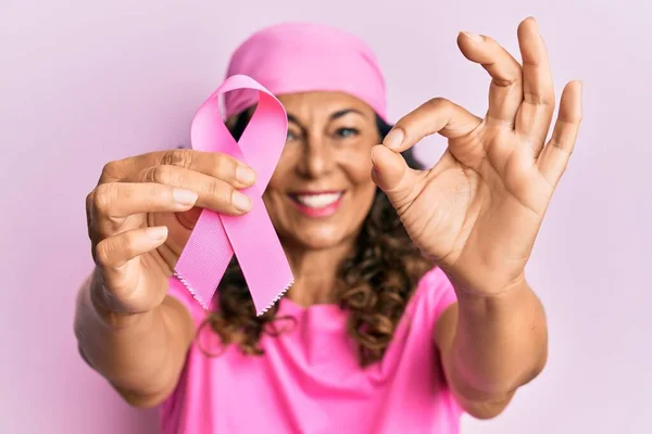 Orta Yaşlı Spanyol Kadın Pembe Kanser Kurdelesi Tutuyor Parmaklarıyla Imza — Stok fotoğraf