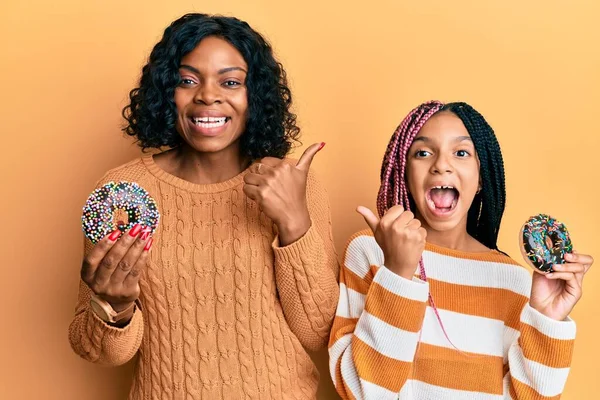 Güzel Afro Amerikan Anne Kızı Ellerinde Donutlar Başparmağıyla Yan Tarafa — Stok fotoğraf