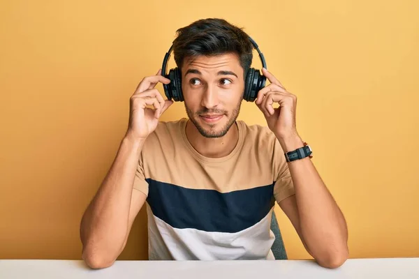 Молодий Красивий Чоловік Слухає Музику Навушниках Посміхаючись Дивиться Бік Дивиться — стокове фото