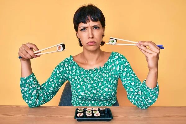 Mulher Bonita Morena Comendo Sushi Sentado Mesa Cético Nervoso Franzindo — Fotografia de Stock