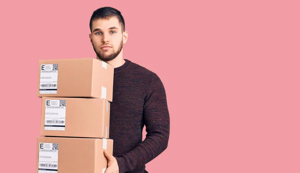 Joven Hombre Guapo Sosteniendo Entrega Paquete Pensamiento Actitud Expresión Sobria — Foto de Stock