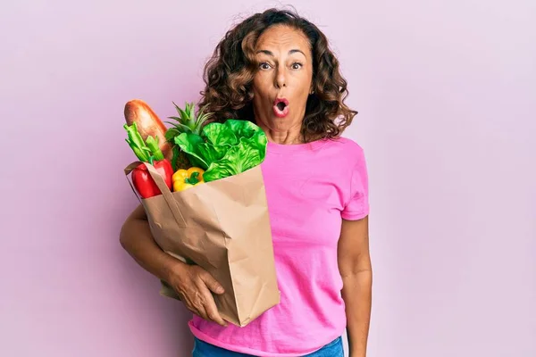 Medelålders Latinamerikansk Kvinna Håller Papperspåse Med Bröd Och Livsmedel Rädd — Stockfoto