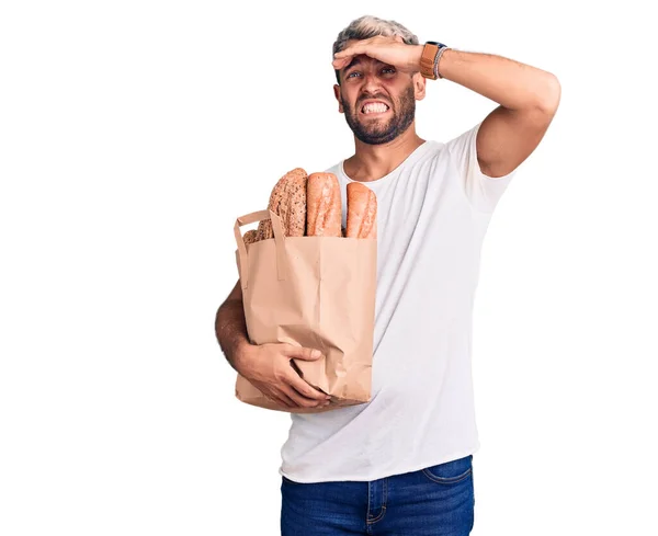 Young Handsome Blond Man Holding Paper Bag Bread Stressed Frustrated — Stock Photo, Image