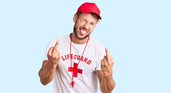 Young Caucasian Man Wearing Lifeguard Shirt Holding Whistle Showing Middle — Stock Fotó