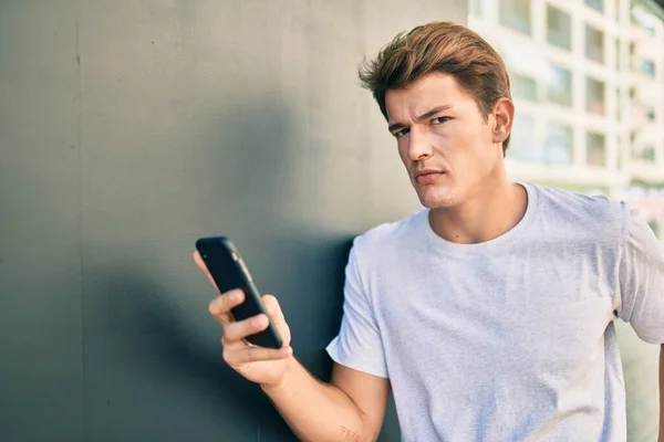 Jonge Kaukasische Man Met Serieuze Expressie Met Smartphone Stad — Stockfoto