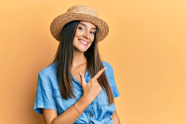 Junge Hispanische Frau Mit Sommerhut Lächelt Fröhlich Und Zeigt Mit — Stockfoto