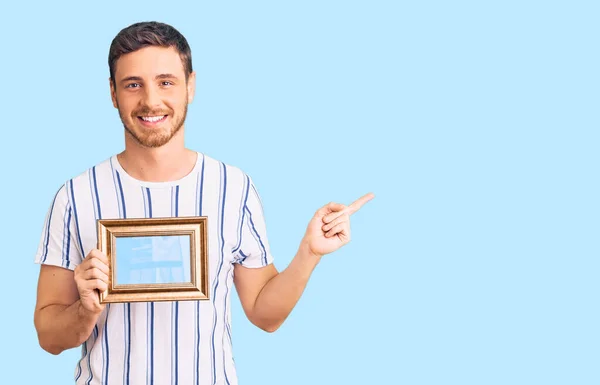 Bonito Jovem Com Urso Segurando Moldura Vazia Sorrindo Feliz Apontando — Fotografia de Stock