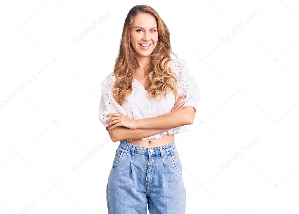 Young caucasian woman with blond hair wearing elegant summer tshirt happy face smiling with crossed arms looking at the camera. positive person. 