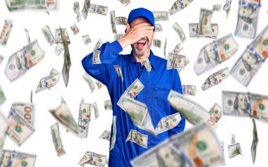 Orta yaşlı yakışıklı, mekanik üniforma giyen, gülümseyen ve gülümseyen bir adam, şaşırmak için gözlerini kapatıyor. kör kavram.