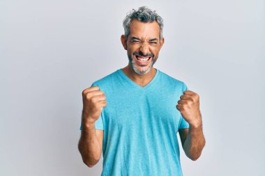 Orta yaşlı, gri saçlı, sıradan kıyafetler giyen, başarı için heyecanlanan, kolları havada, gözleri kapalı, zaferi kutlayan bir adam. Kazanan konsept. 