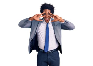 Yakışıklı, afro saçlı, iş ceketi giyen, barış sembolü çizen, gülümseyen, zafer gösteren afro-amerikalı adam. 