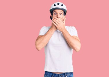 Bisiklet kaskı takan genç yakışıklı adam ağzını yanlışlıkla ellerle kapatırken şok oldu. gizli kavram. 