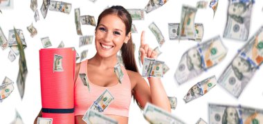 Elinde yoga minderi tutan genç ve güzel bir İspanyol kadın bir fikre ya da soru işaretine şaşırdı.