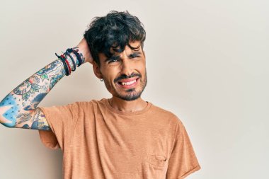 Gündelik kıyafetler giyen genç İspanyol adam soru sorup kafasını karıştırıyor. Şüpheyle kararsız, kafa kafaya düşünerek. Düşünceli kavram. 