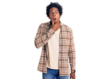 Afro saçlı, sıradan giyinmiş ve gözlüklü yakışıklı Afro-Amerikalı adam. İnançsızlıktan, şaşkınlıktan ve elleri çenesinde olan şaşkınlıktan büyülenmiş görünüyor. 
