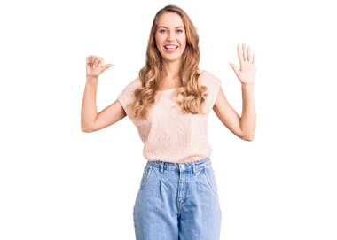 Sarışın, güzel, beyaz bir kadın. Sıradan kıyafetler giyiyor. Altıncı parmaklarını gösterip gülümsüyor.. 