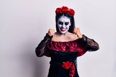 Meksika makyajlı genç bir kadın. Başarının heyecanı içinde kolları havada ve gözleri kapalı zaferi kutlarken gülümsüyor. Kazanan konsept. 